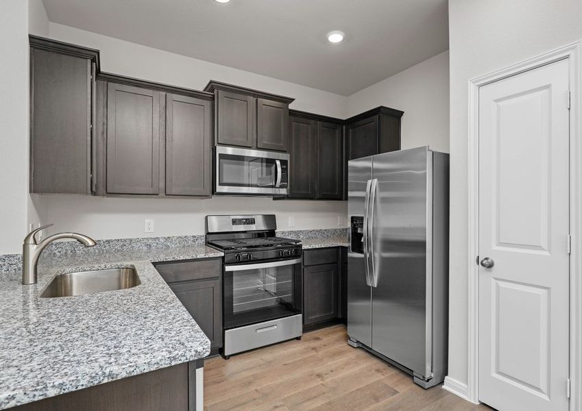 The kitchen  has designer wood cabinetry.