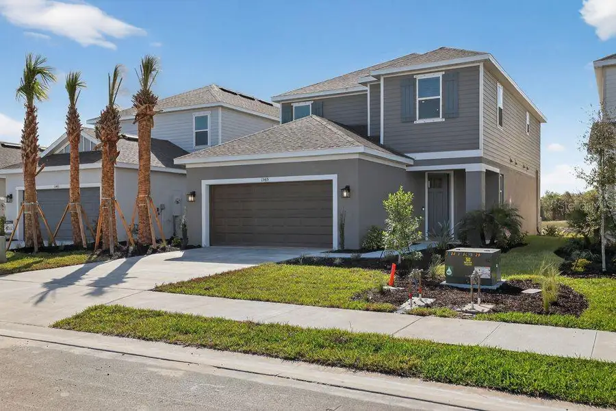 Front exterior of a new home in Firethorn, Parrish, FL, highlighting curb appeal (Image 21).