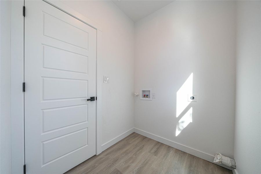 Washroom featuring hookup for a washing machine, light wood finished floors, and electric dryer hookup