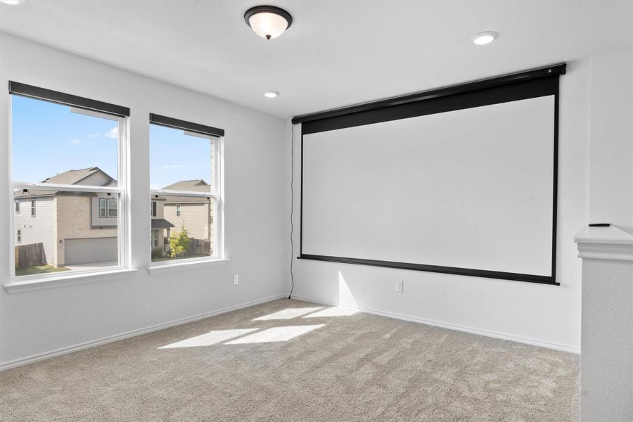 Carpeted cinema room with baseboards and recessed lighting