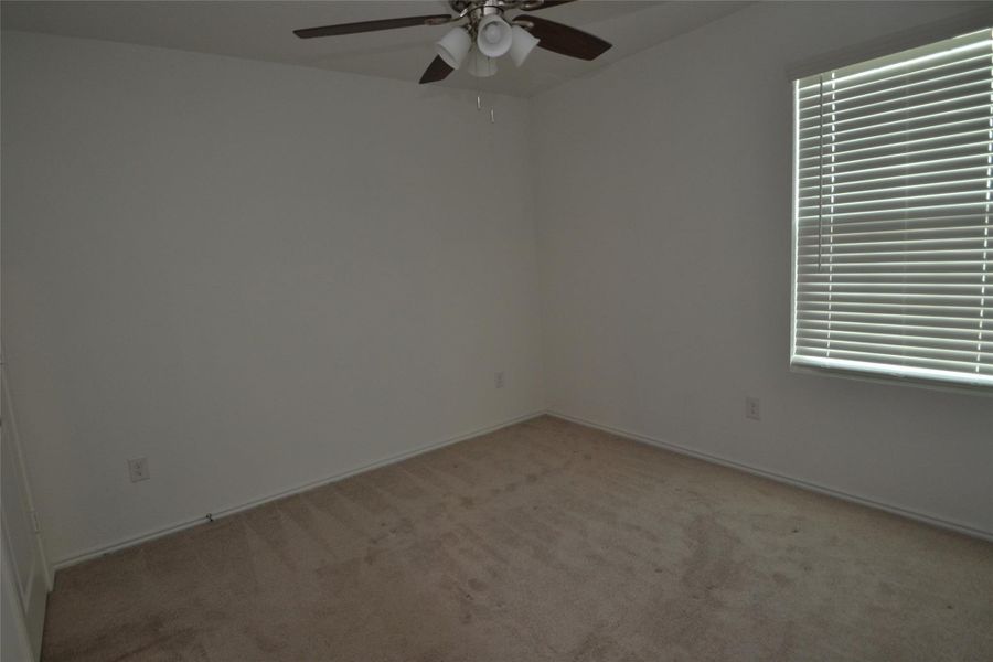 Unfurnished room with light colored carpet and ceiling fan