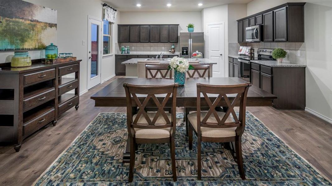Dining room with recessed lighting and dark wood-style flooring