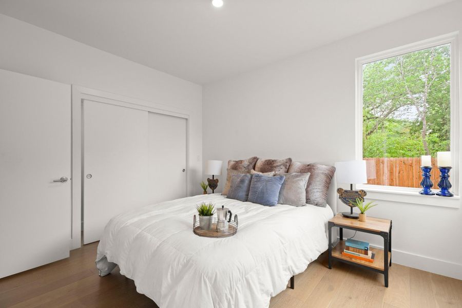 Bedroom featuring wood-finish flooring and a large window