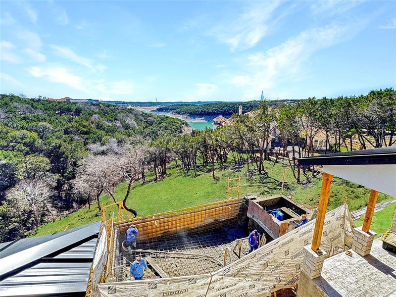 Survey the landscape from the upstairs balcony, where the pool and spa are currently in progress. The lush greenery has been virtually added, offering a glimpse of the serene surroundings. This property promises an exceptional space for absolute enjoyment.