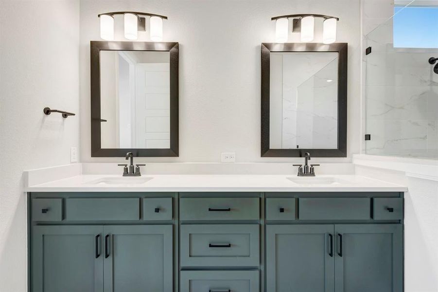 Bathroom with double vanity and a marble finish shower