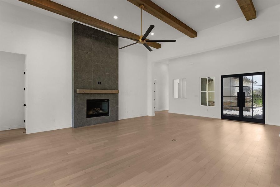 A spacious living area with exposed beams and a modern fireplace.