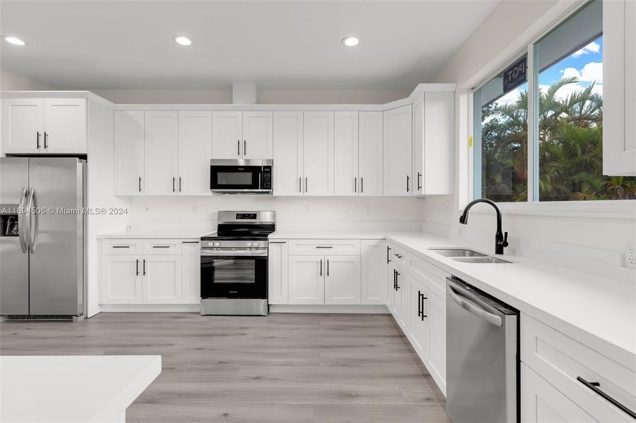 CUSTOM KITCHEN W/ CENTER ISLAND OVERLOOKING THE OPEN FLOOR PLAN LIVING ROOM.