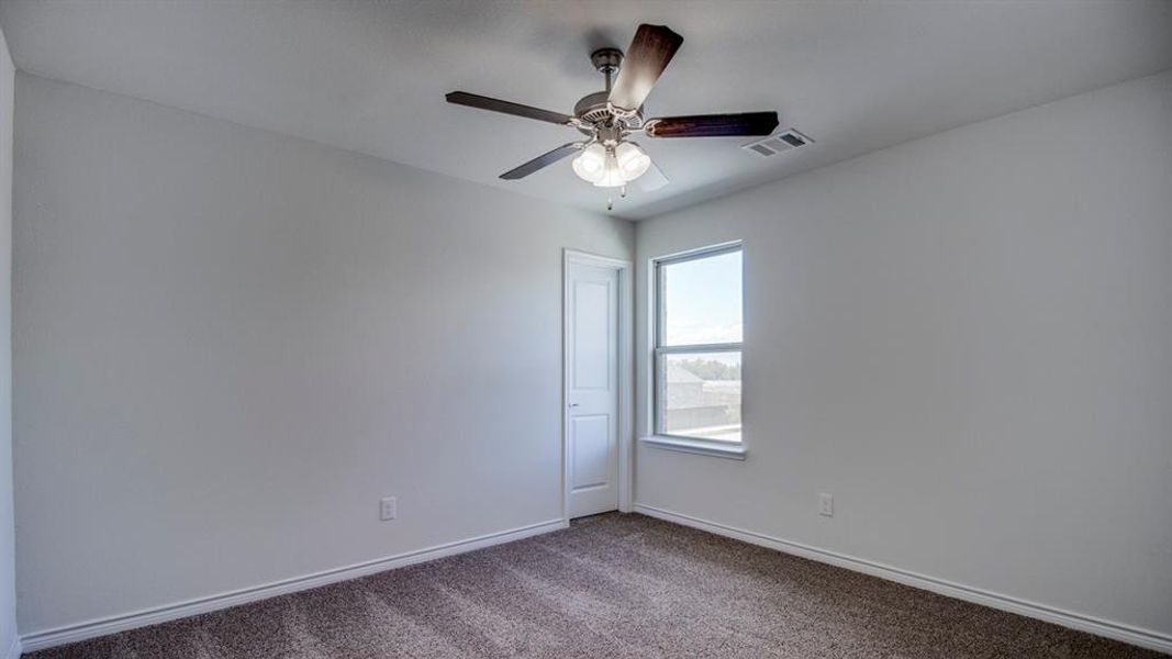 Empty room featuring carpet flooring and ceiling fan Empty room featuring carpet flooring and ceiling fan