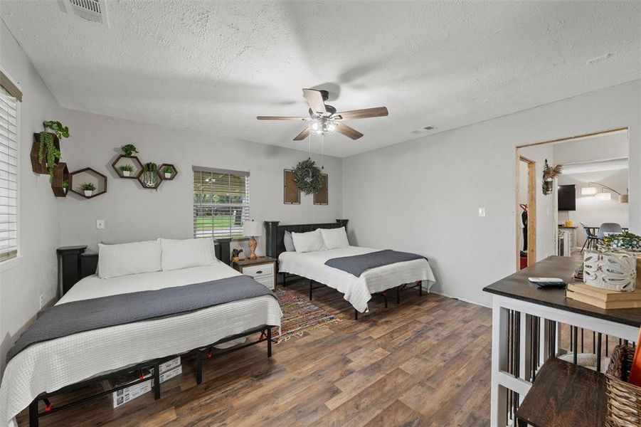 Bedroom featuring wood finished floors, a textured ceiling, and a ceiling fan Bedroom featuring wood finished floors, a textured ceiling, and a ceiling fan
