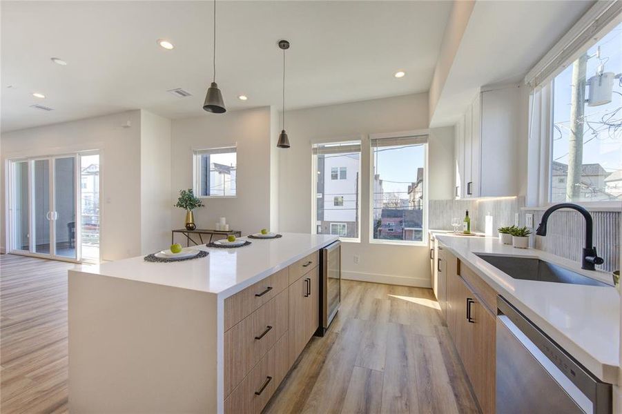 Natural light floods this stunning kitchen with views of East River overlooking the sink! This kitchen features European style white oak and white slim shaker soft-close cabinetry, beautiful custom tile backsplash, white quartz with a 2 inch thick waterfall island, and large walk-in corner pantry.