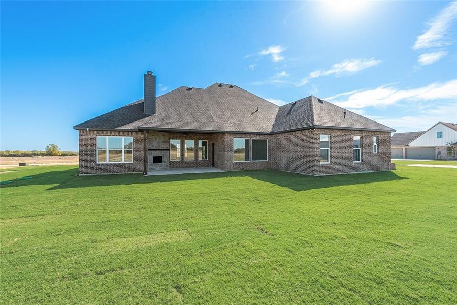 Back of house with a yard and a patio