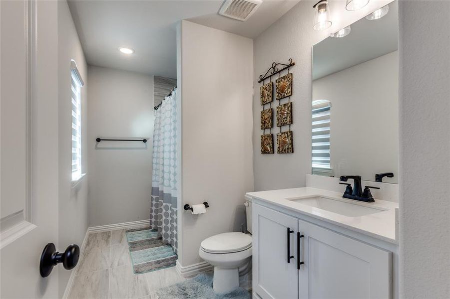 Bathroom featuring a shower with curtain and vanity