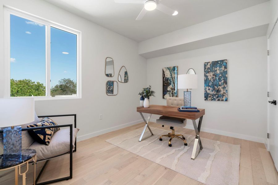 Office with light wood-type flooring and a ceiling fan