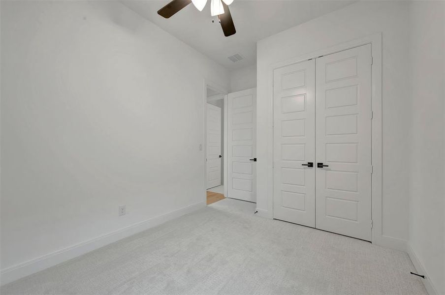 Spacious interior room featuring light gray carpeting and white baseboards