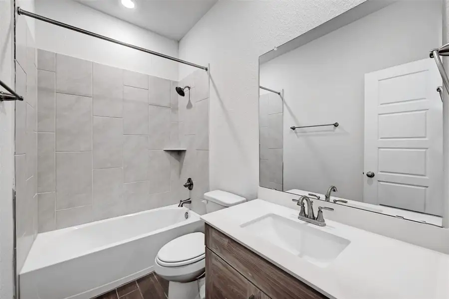 Full bath featuring vanity, wood finished floors, bathing tub / shower combination, and recessed lighting Full bath featuring vanity, wood finished floors, bathing tub / shower combination, and recessed lighting