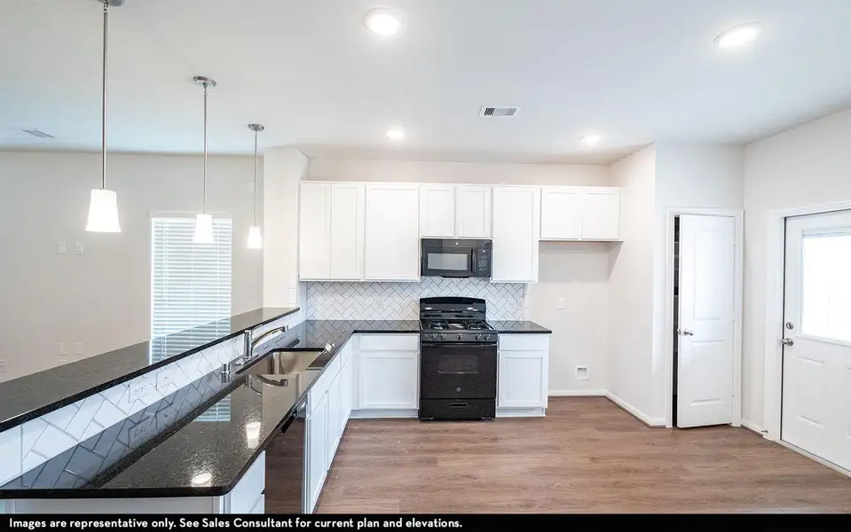 Kitchen with white cabinets, visible vents, black appliances, a sink, and backsplash
