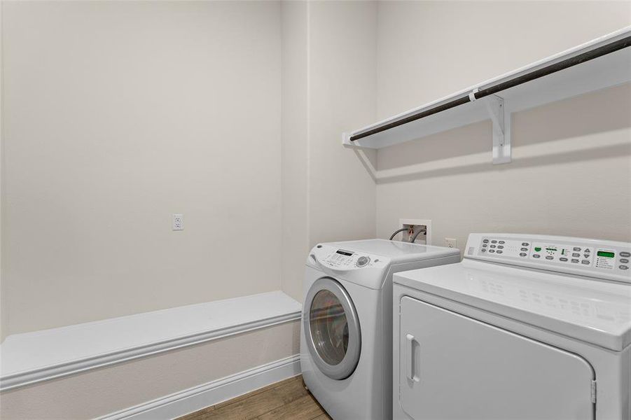 Laundry area with light wood-style floors and washer and clothes dryer Laundry area with light wood-style floors and washer and clothes dryer