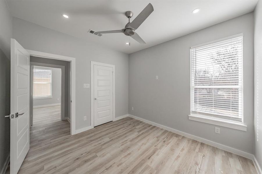 Unfurnished bedroom with ceiling fan, a closet, and light wood-type flooring