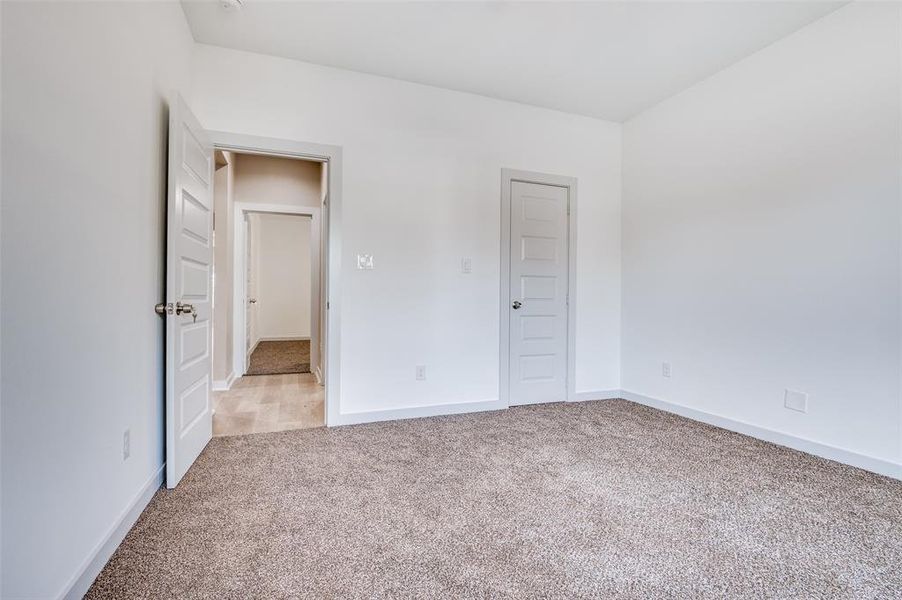 Unfurnished bedroom featuring baseboards and carpet