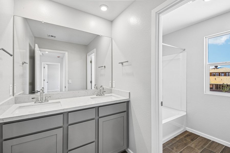 A bathroom with a sink and a mirror. A bathroom with a sink and a mirror.