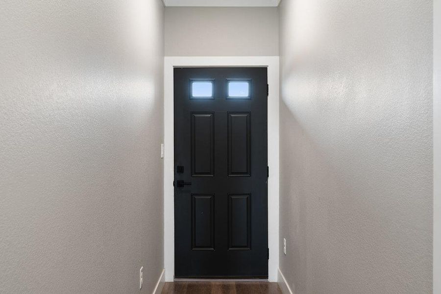 Entryway with wood finished floors and baseboards