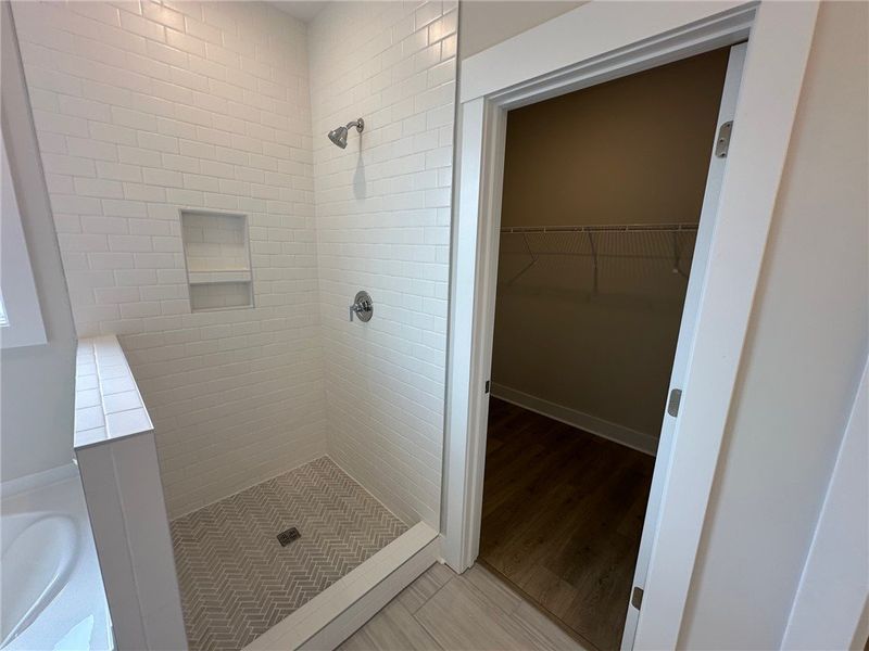 This sleek shower and adjacent closet provide prac