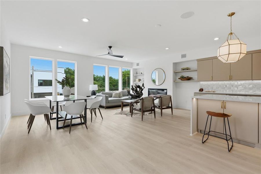Open-concept living space featuring wood-finish flooring, recessed lighting, and multiple large windows Open-concept living space featuring wood-finish flooring, recessed lighting, and multiple large windows