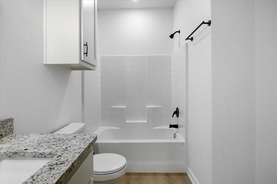 Bathroom with shower / bathtub combination, vanity, and light wood finished floors