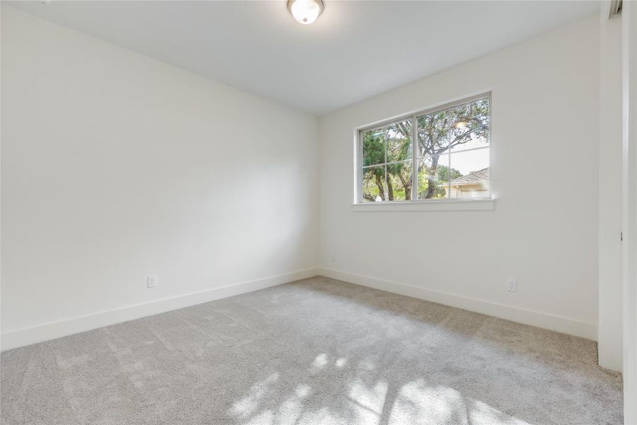 Carpeted spare room featuring baseboards Carpeted spare room featuring baseboards