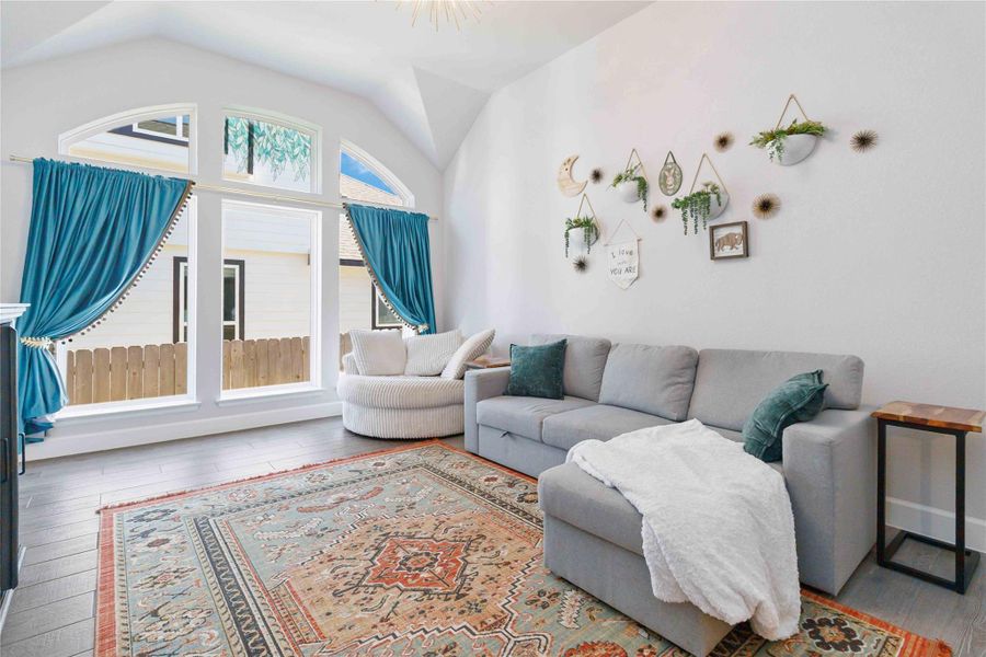 Living area featuring wood finished floors and lofted ceiling Living area featuring wood finished floors and lofted ceiling