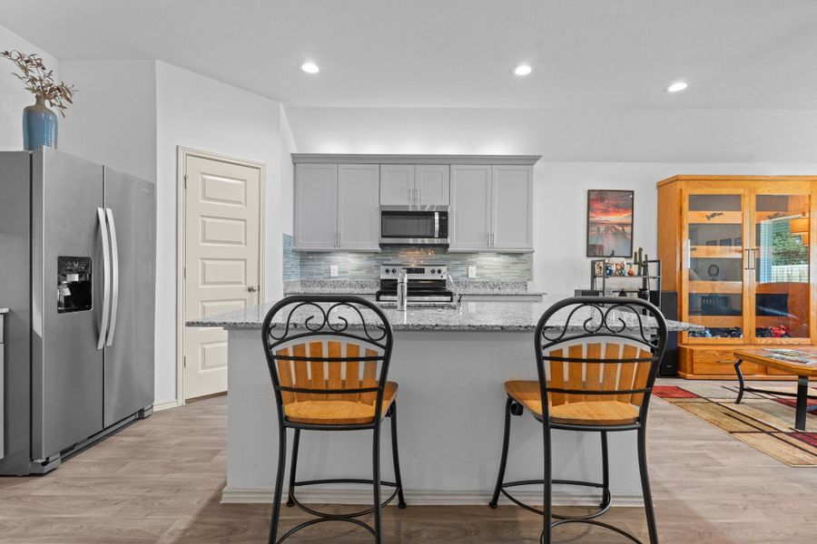 Stylish gourmet kitchen with sleek granite countertops, tall shaker cabinets, undermount and upper mount lighting, crown molding, stainless steel appliances, and a spacious island with seating — ideal for prep work or a quick bite. Stylish gourmet kitchen with sleek granite countertops, tall shaker cabinets, undermount and upper mount lighting, crown molding, stainless steel appliances, and a spacious island with seating — ideal for prep work or a quick bite.