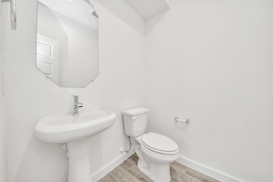 This half bathroom features a stylish pedestal sink, modern hardware, and bright recessed lighting, creating a sleek and inviting space. This half bathroom features a stylish pedestal sink, modern hardware, and bright recessed lighting, creating a sleek and inviting space.