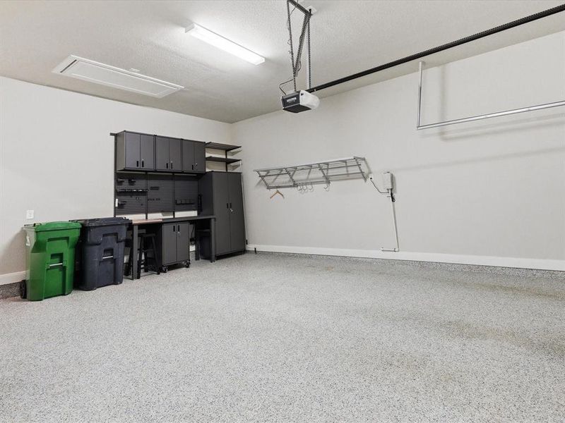 Garage with Epoxy Flooring, Cabinetry for Storage, and extra storage space not shown.