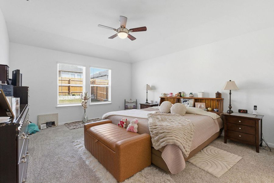 Carpeted bedroom with a ceiling fan and baseboards