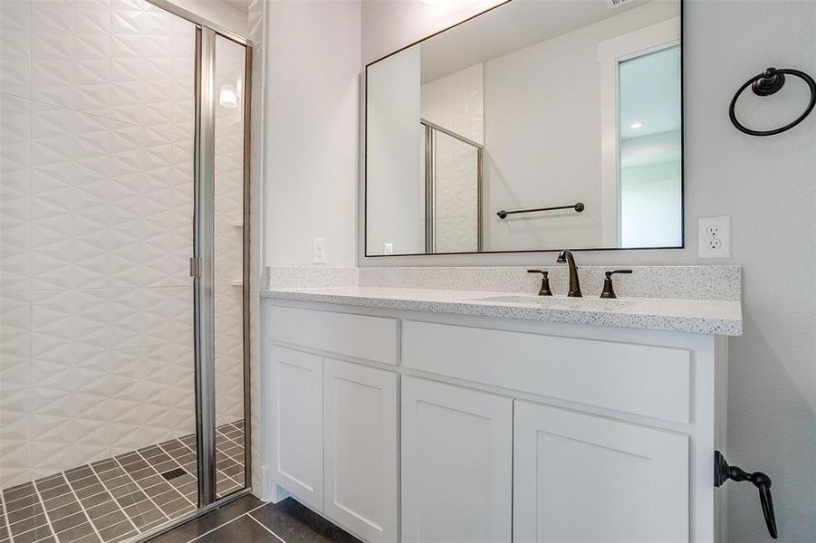 Bathroom with vanity, tile patterned flooring, and walk in shower