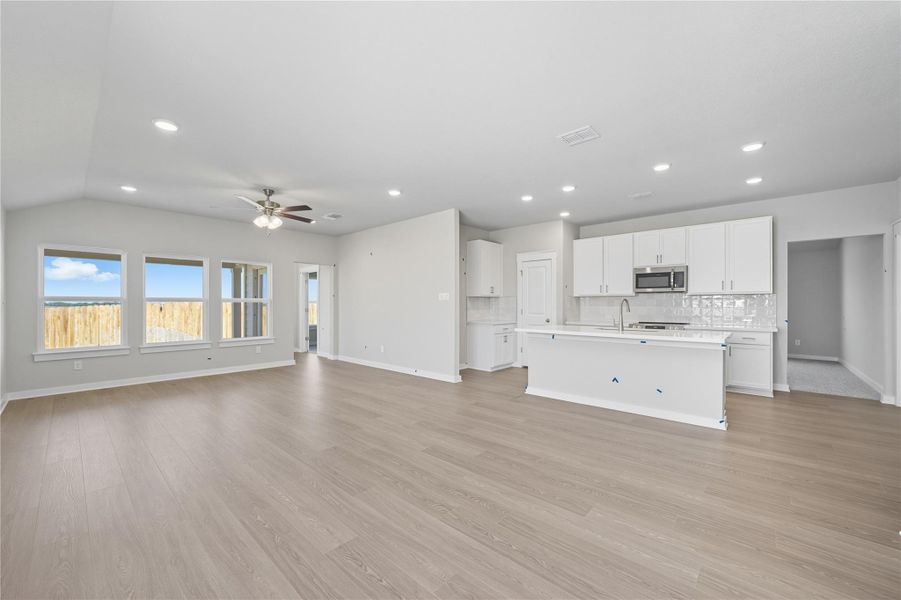 Unfurnished living room featuring light wood finished floors, recessed lighting, and a ceiling fan Unfurnished living room featuring light wood finished floors, recessed lighting, and a ceiling fan