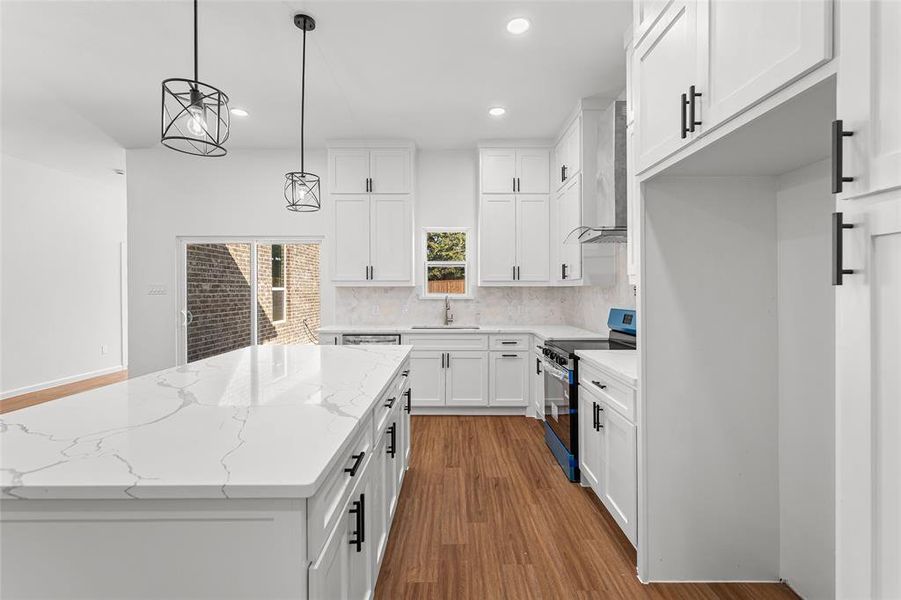 Kitchen featuring dark wood-style floors, white cabinetry, backsplash, decorative light fixtures, and range with electric stovetop