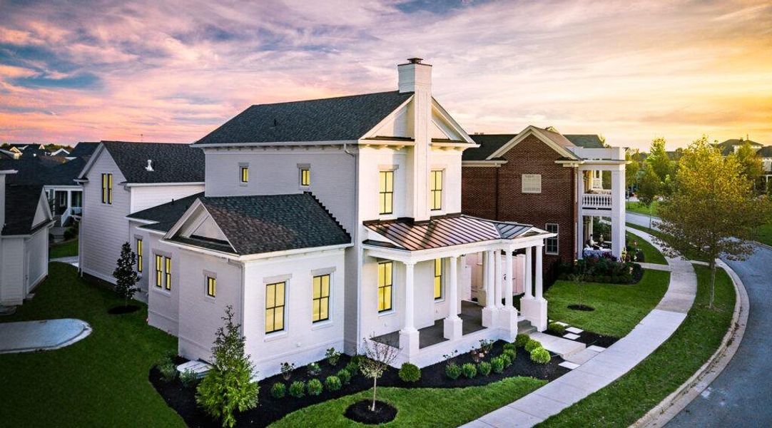 Front/Side of house at dusk with a porch, a chimney, a lawn, and a shingled roof. Please note these are pictures of home to be built. Photos are copyrighted by C3Studios, LLC.