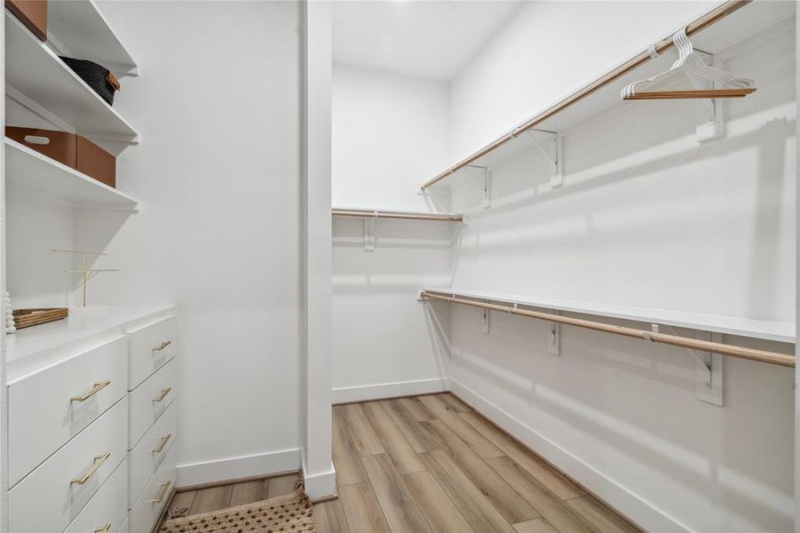 This spacious primary closet is designed with ample shelving, hanging space, and built-in drawers, offering plenty of room to organize and store your wardrobe in style.