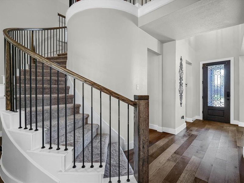 Foyer with a textured ceiling, dark wood-type flooring, and a high ceiling Foyer with a textured ceiling, dark wood-type flooring, and a high ceiling