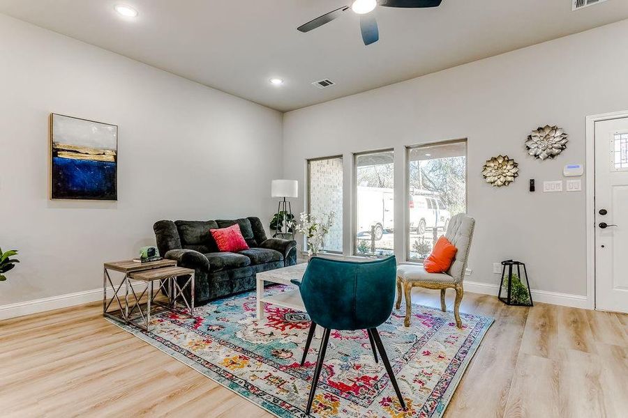 Living room with ceiling fan and light hardwood / wood-style floors