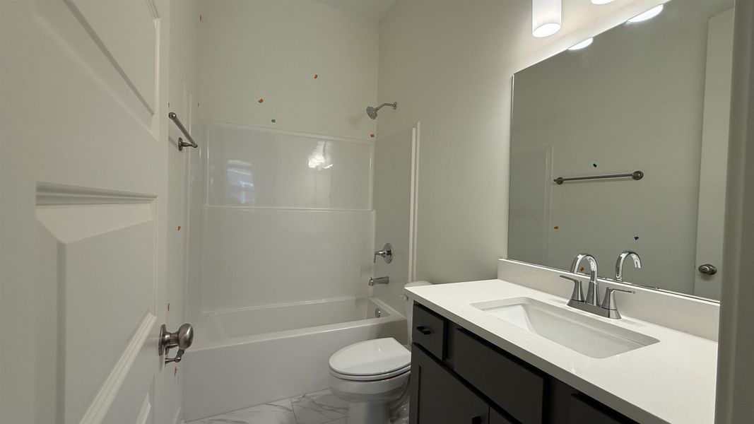 Bathroom with vanity, shower / bathtub combination, and light marble finish floors