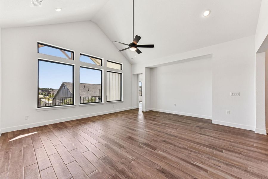 Spare room featuring high vaulted ceiling, a ceiling fan, dark wood finished floors, and recessed lighting