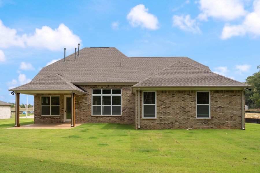 Brick exterior with a shingle roof and covered patio featuring wood posts Brick exterior with a shingle roof and covered patio featuring wood posts