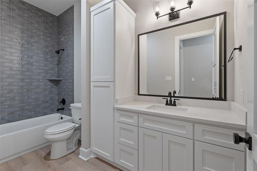 Secondary Bathroom, Custom Cabinetry, Framed Mirror, Oil Rubbed Bronze Fixtures, Grey Subway Tiles in the Shower