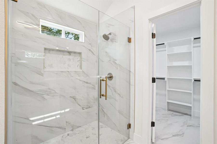 Bathroom with a marble finish shower, light marble finish flooring, and a spacious closet Bathroom with a marble finish shower, light marble finish flooring, and a spacious closet