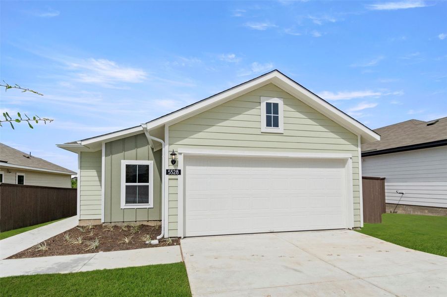 Single story home with board and batten siding, a garage, and an outbuilding