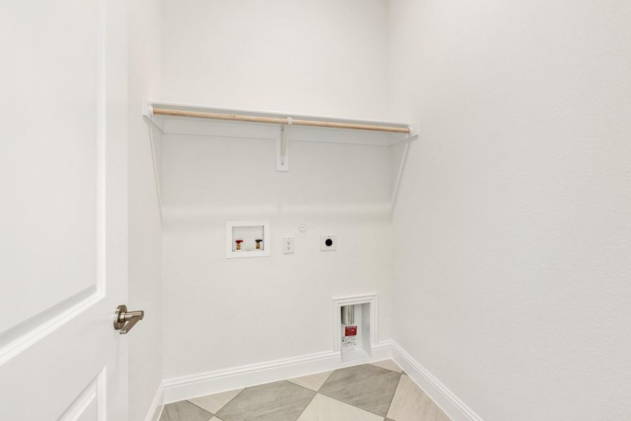 Laundry room with upper shelf, washer hookups, dryer vent, and tile floor