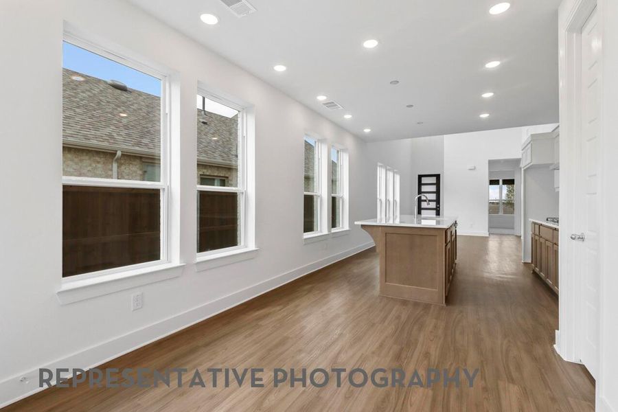 The dining area, located adjacent to the kitchen, is filled with natural light from its windows, creating a bright and inviting space for meals.