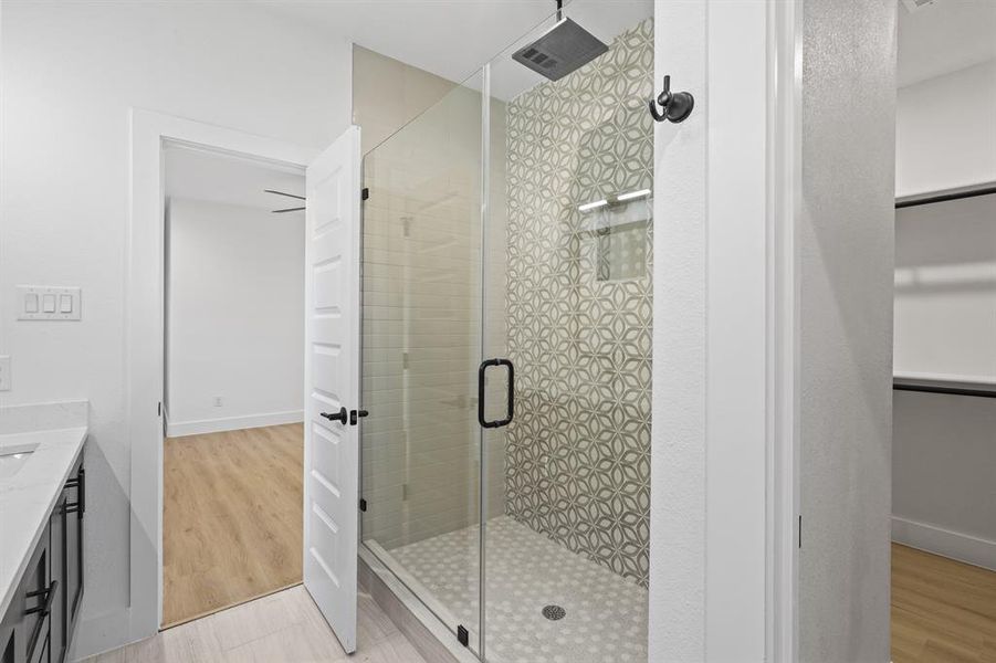 Bathroom with vanity, hardwood / wood-style flooring, and a shower with shower door